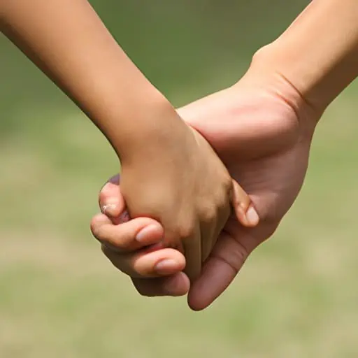 יד בוגרת אוחזת ביד ילד, מסמלת הדרכה, תמיכה ואמונה.